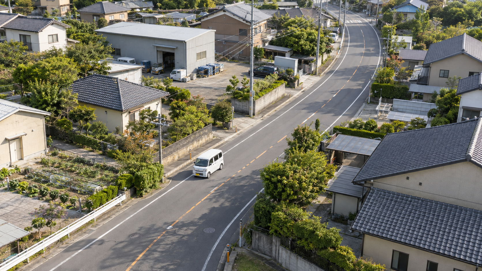 住宅街の道路を巡る軽配送車